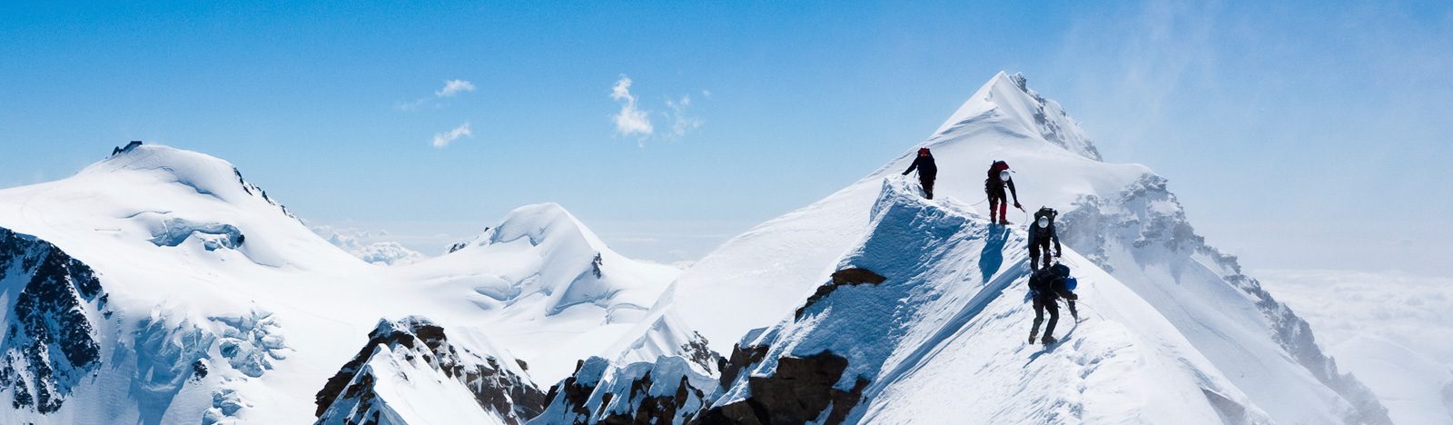 People hiking on top of snowy mountain